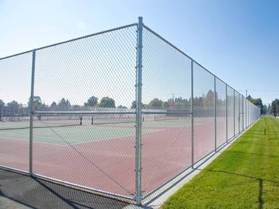 二重ゲートが付いているポリマー上塗を施してあるテニス コートの塀。