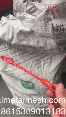 コンチェルティーナ・ワイヤーとワイヤーの間を通る赤いプラスチック支柱クリップ