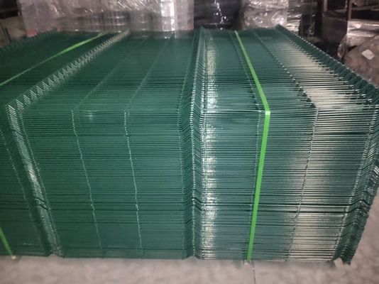 まっすぐなポストは上塗を施してある曲げられた金属の塀をパネルをはめる三角形のくねりの金網に粉にする